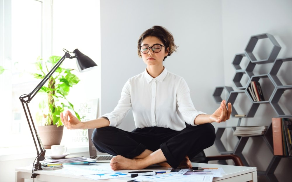 the girl sits on the desk and meditates